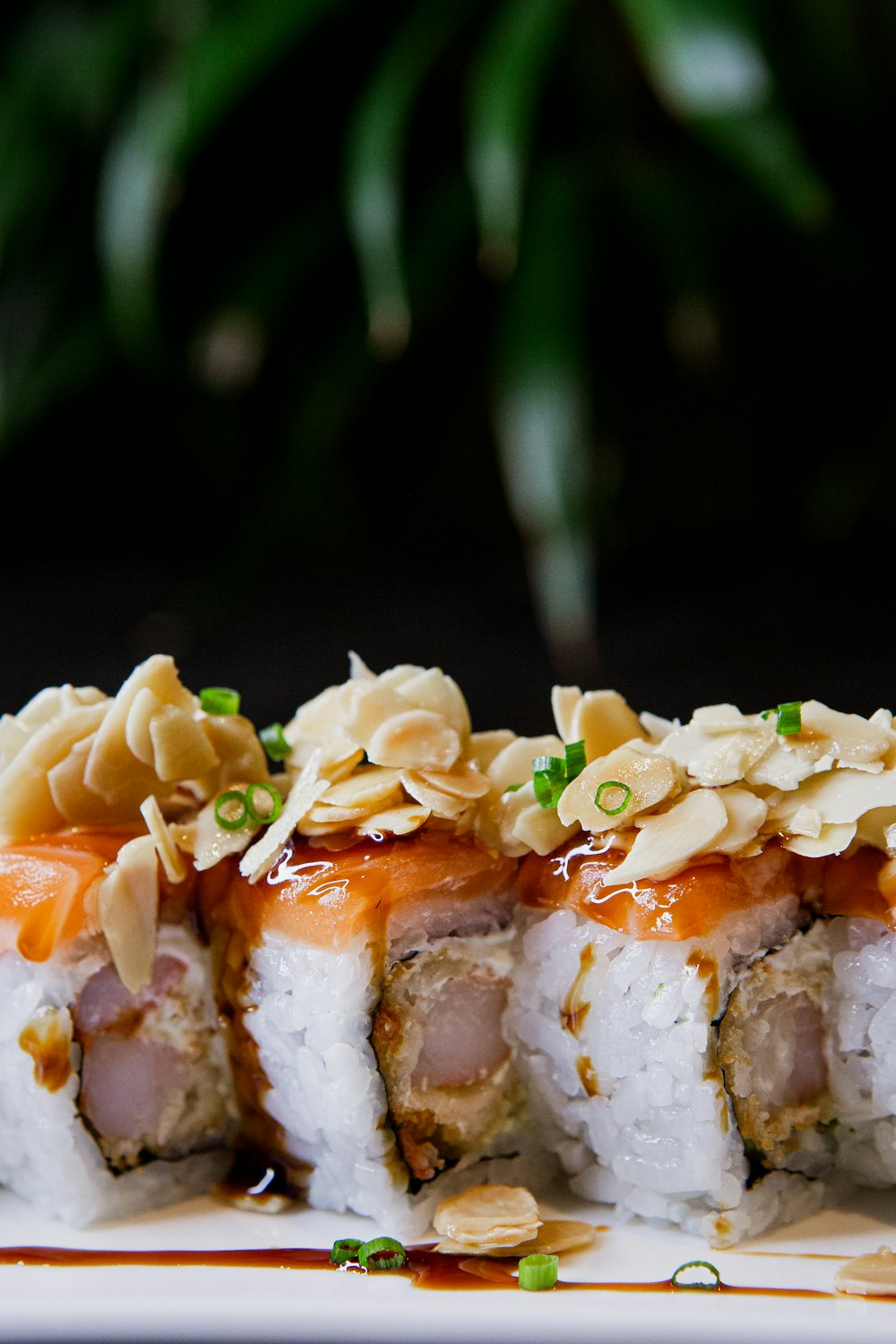 a white plate topped with sushi covered in sauce