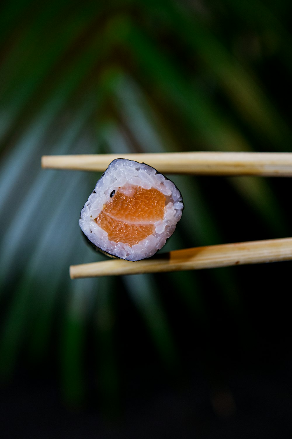 two chopsticks with a sushi on them