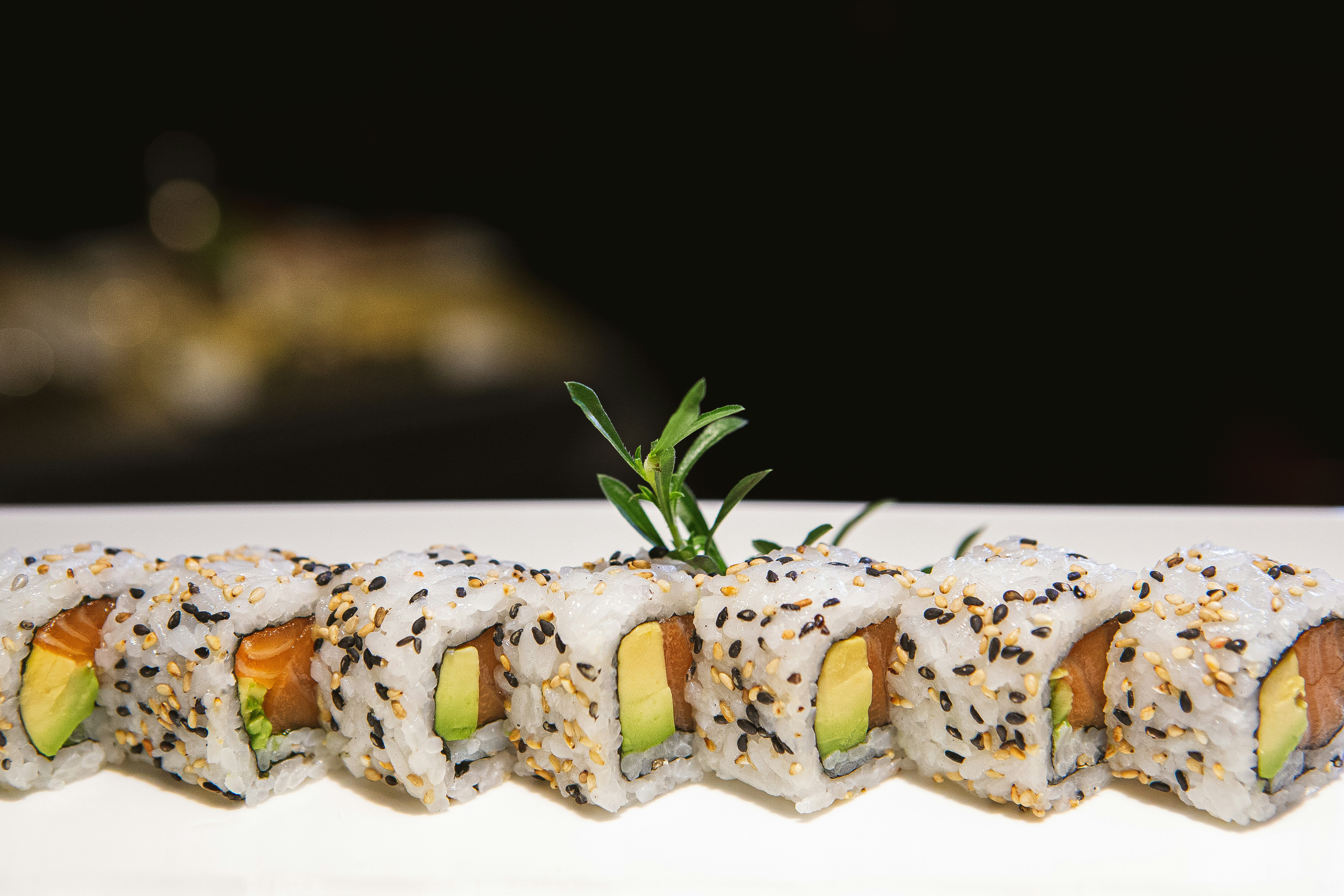 a white plate topped with sushi covered in sauce