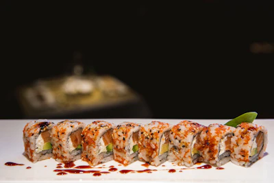 Vibrant bowl of colorful sushi rolls arranged neatly on a black plate