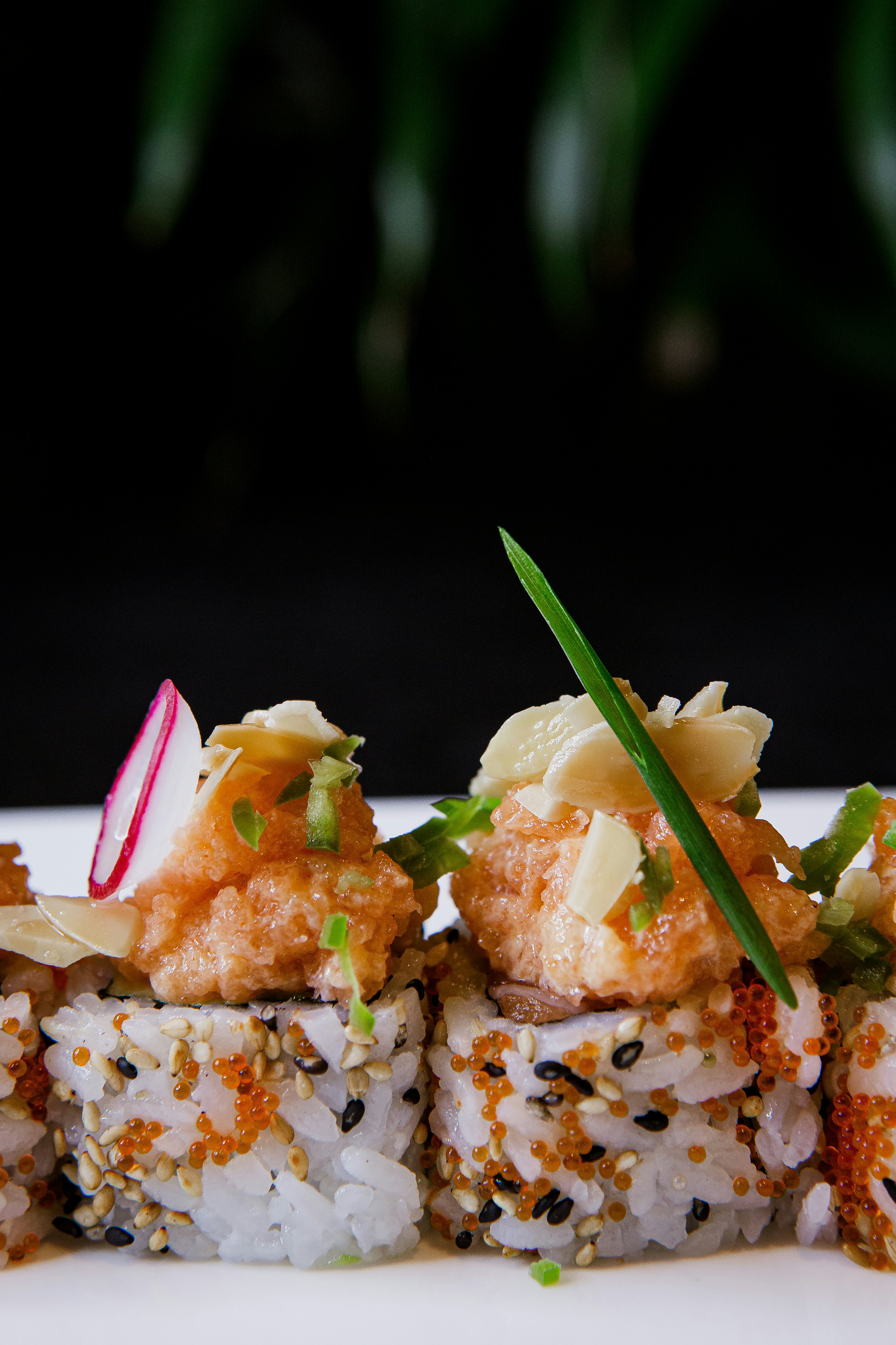 a white plate topped with sushi covered in sauce