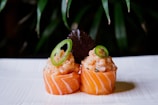 two sushi rolls with avocado on top of them