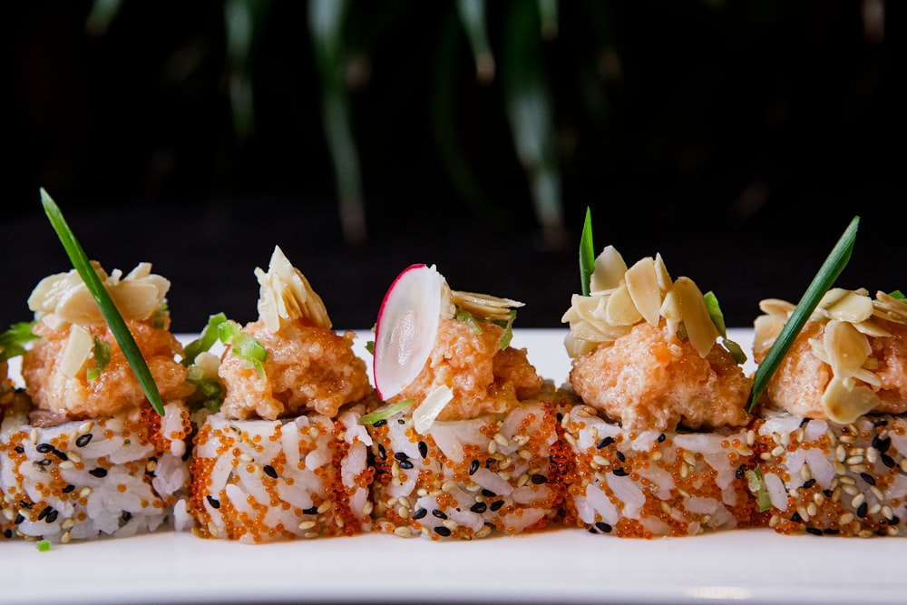 a white plate topped with sushi covered in sauce