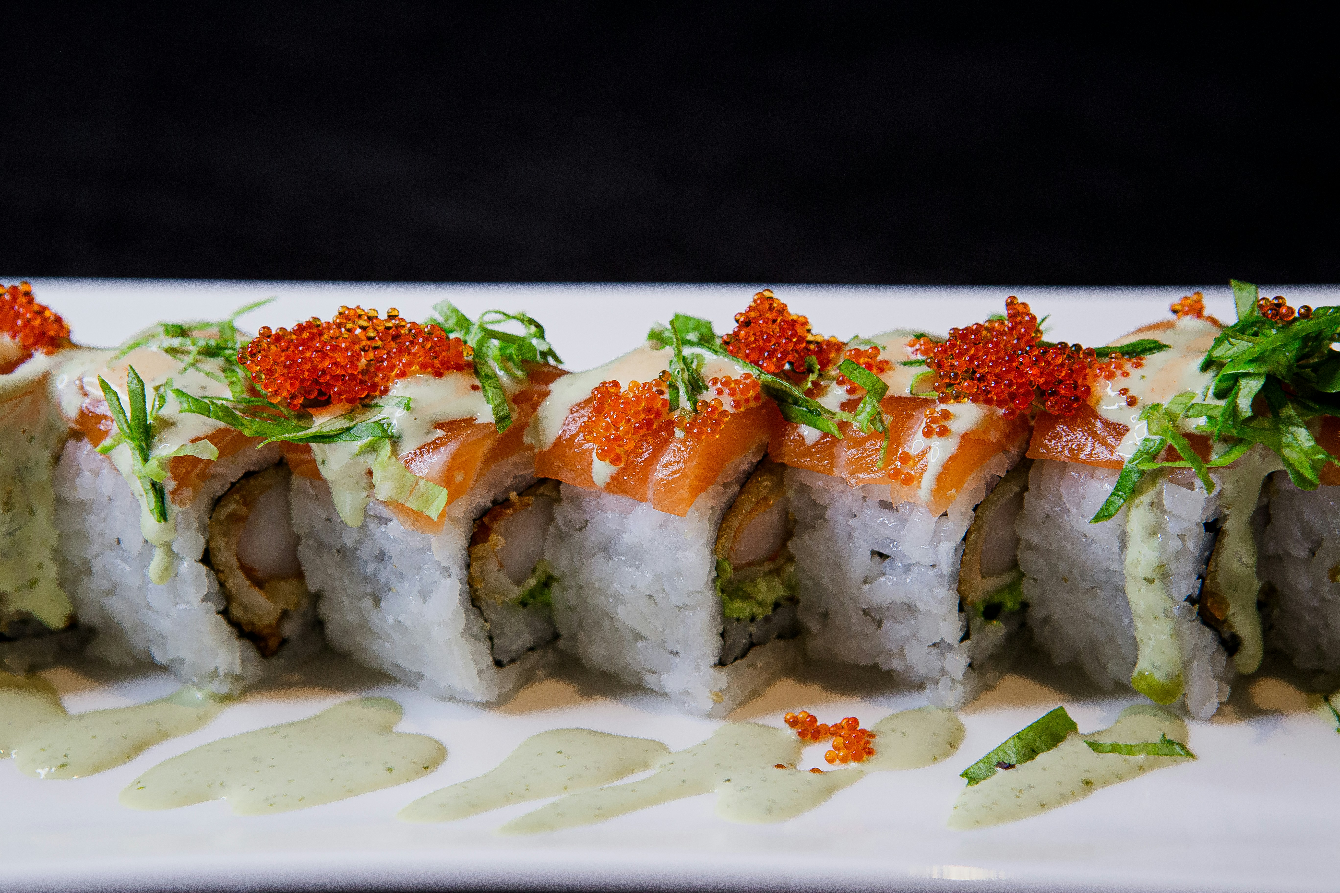 A white plate topped with sushi covered in sauce photo – Free Sushi