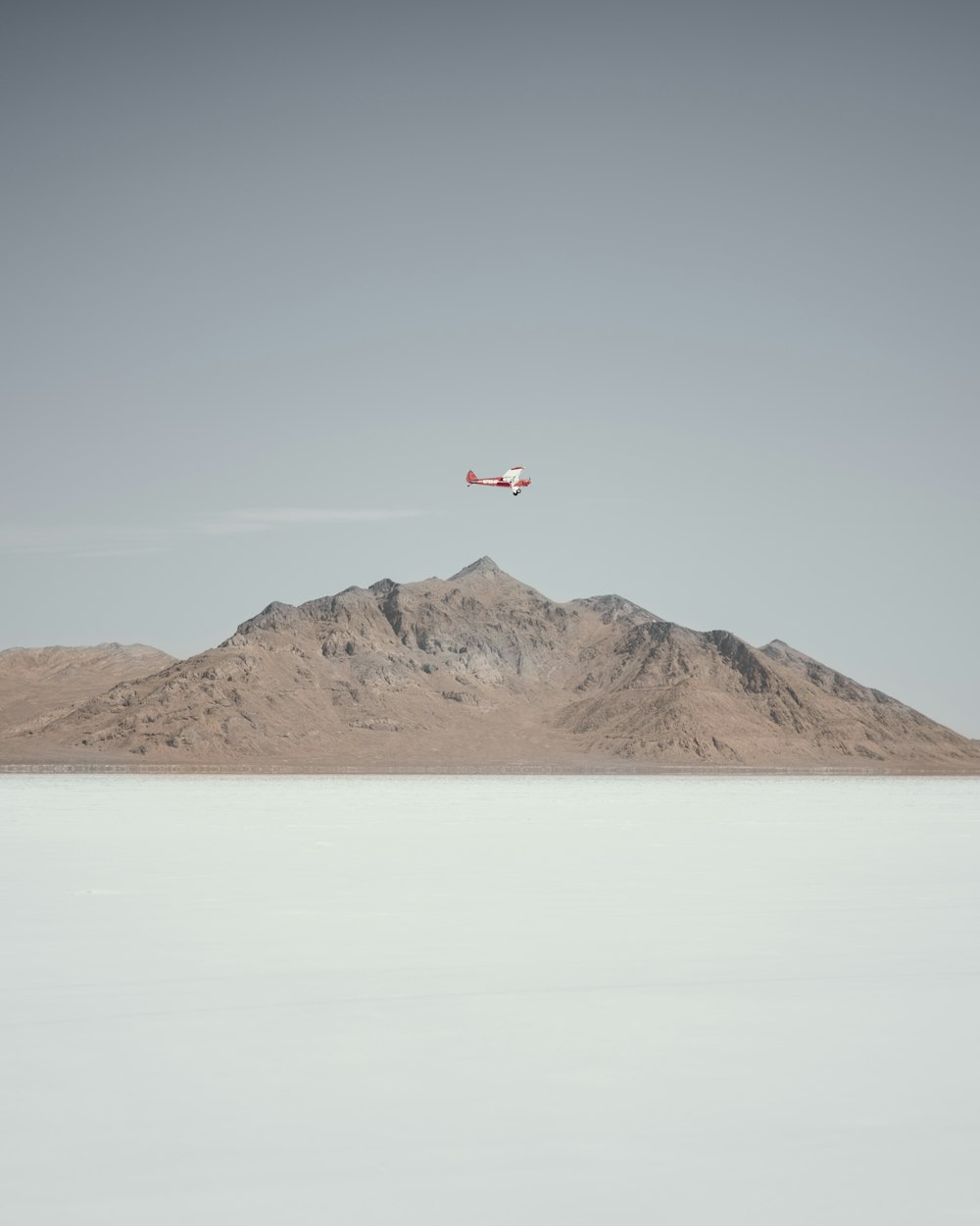 a small plane flying over a mountain range