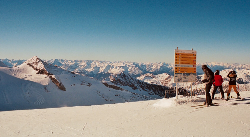 a group of people standing on top of a snow covered slope