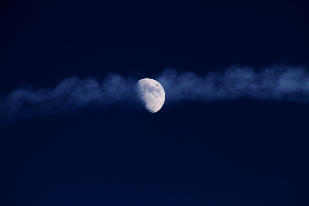 a plane flying in the sky with a moon in the background