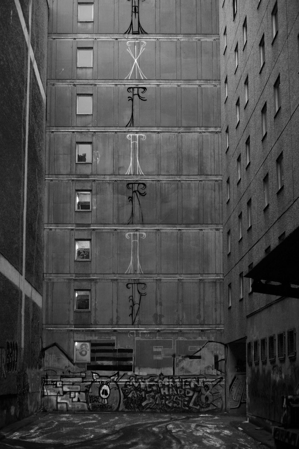 a black and white photo of a building with graffiti on it