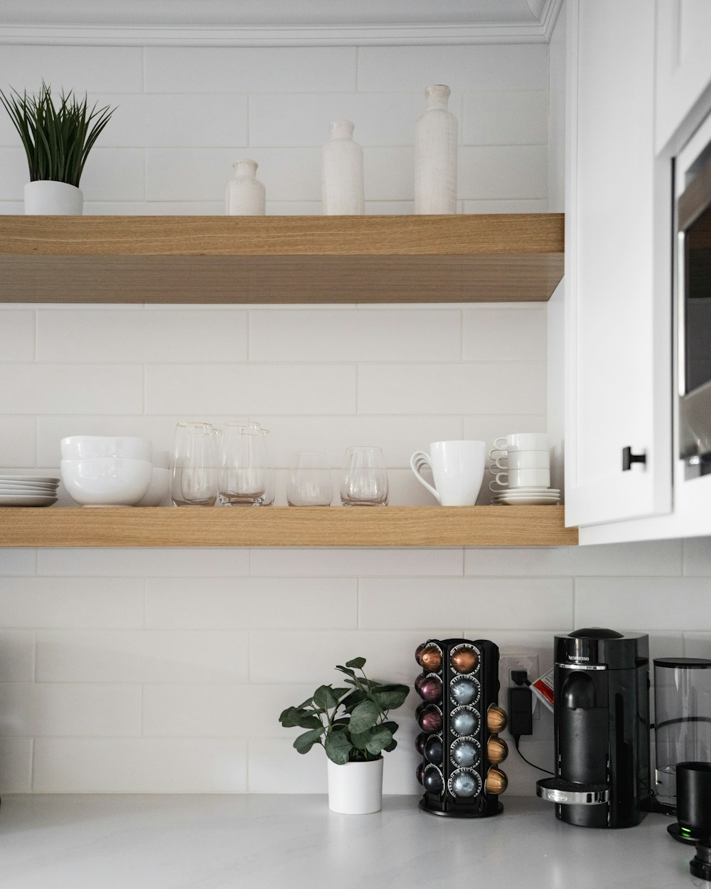a kitchen counter with a coffee maker and cups on it