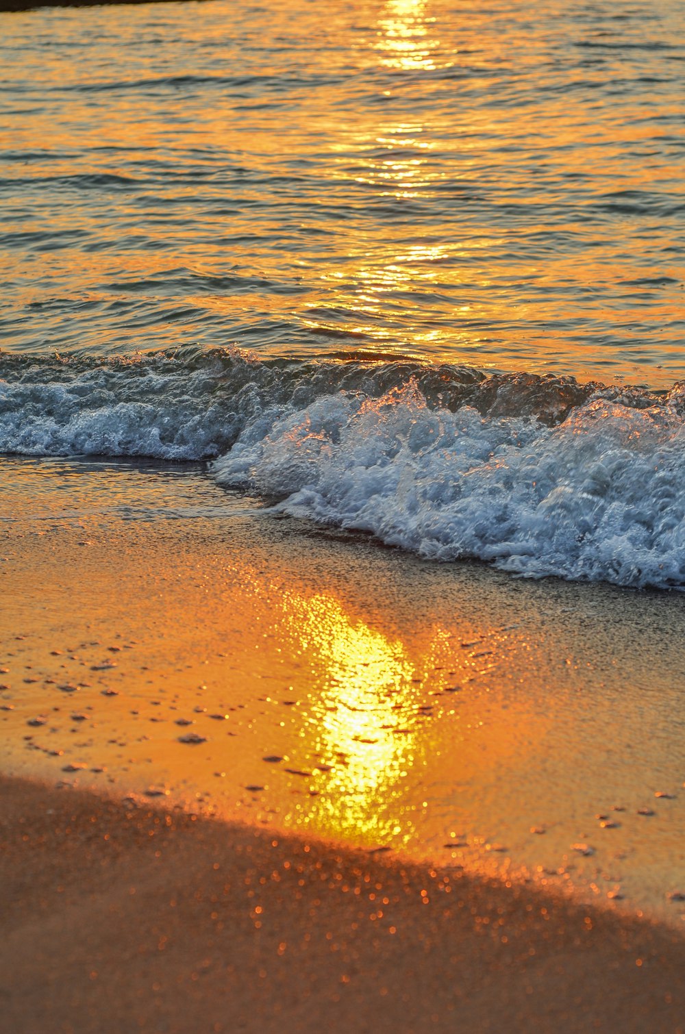 il sole sta tramontando sull'acqua in spiaggia