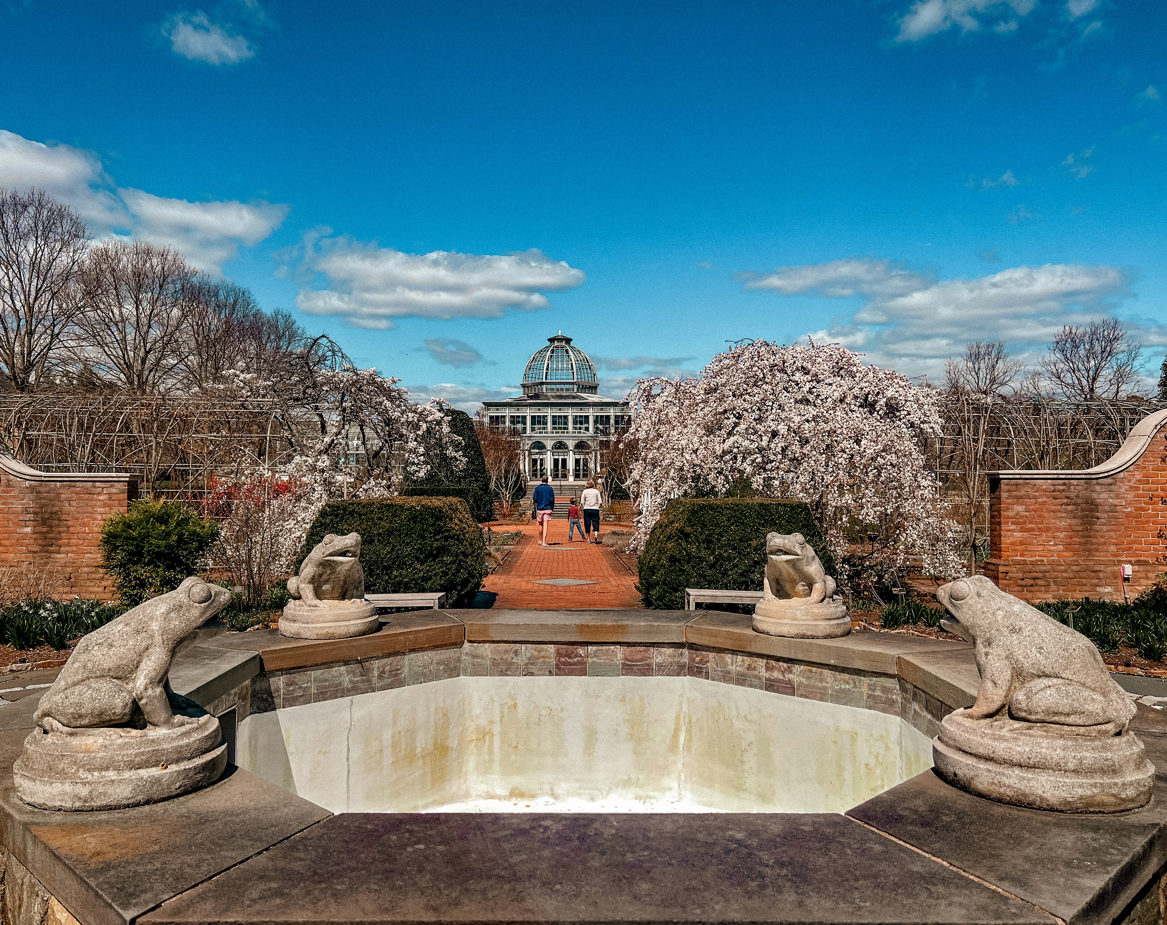 un étang avec des statues de lions devant un bâtiment