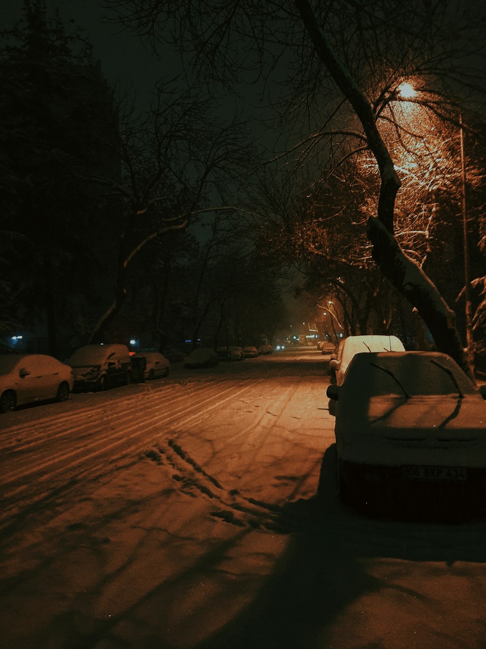 a car parked on a snowy street at night