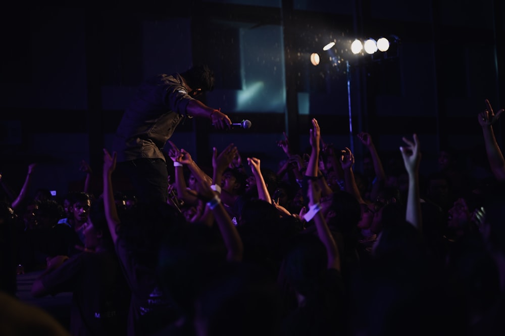 a man standing on top of a stage in front of a crowd