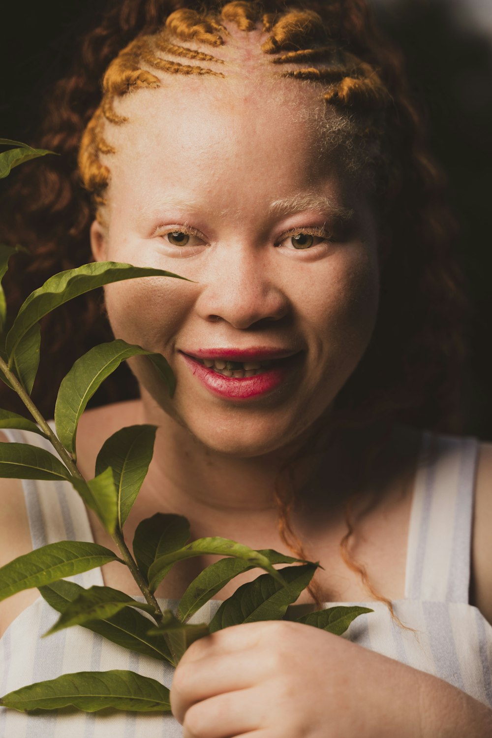 a woman with red lipstick holding a plant