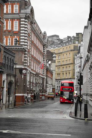a red double decker bus driving down a city street