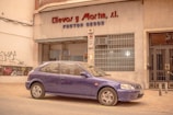 a purple car parked in front of a building