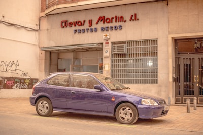 a purple car parked in front of a building