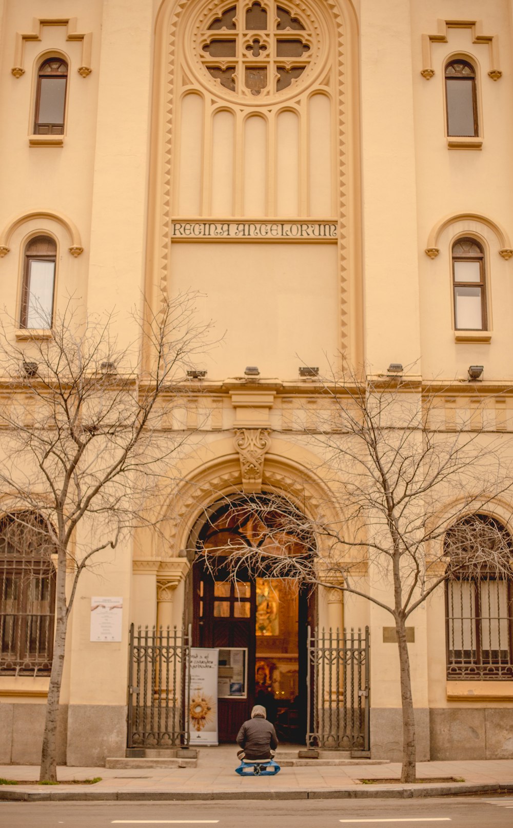 a person sitting on a bench in front of a building