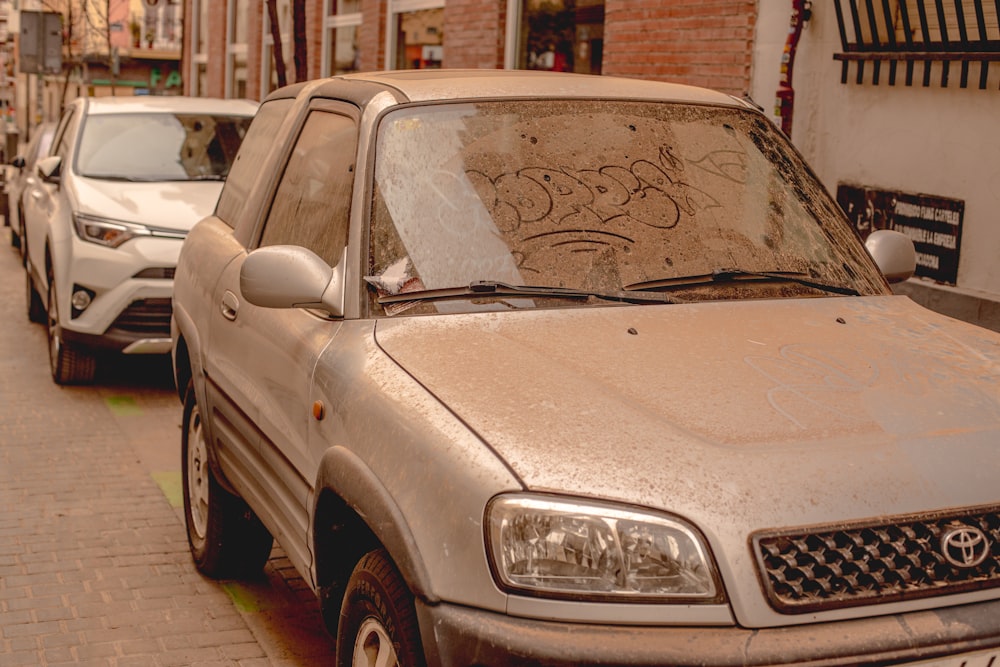 a dirty car parked on the side of the road