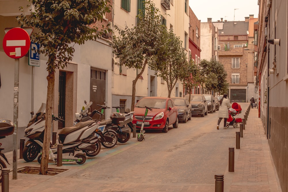 a street lined with parked motorcycles next to tall buildings