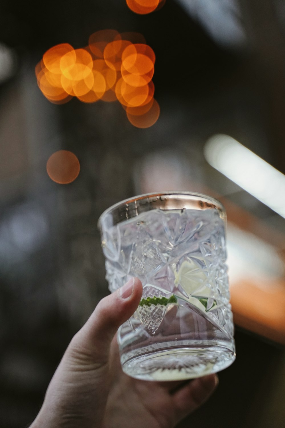 a person holding a glass with a flower in it