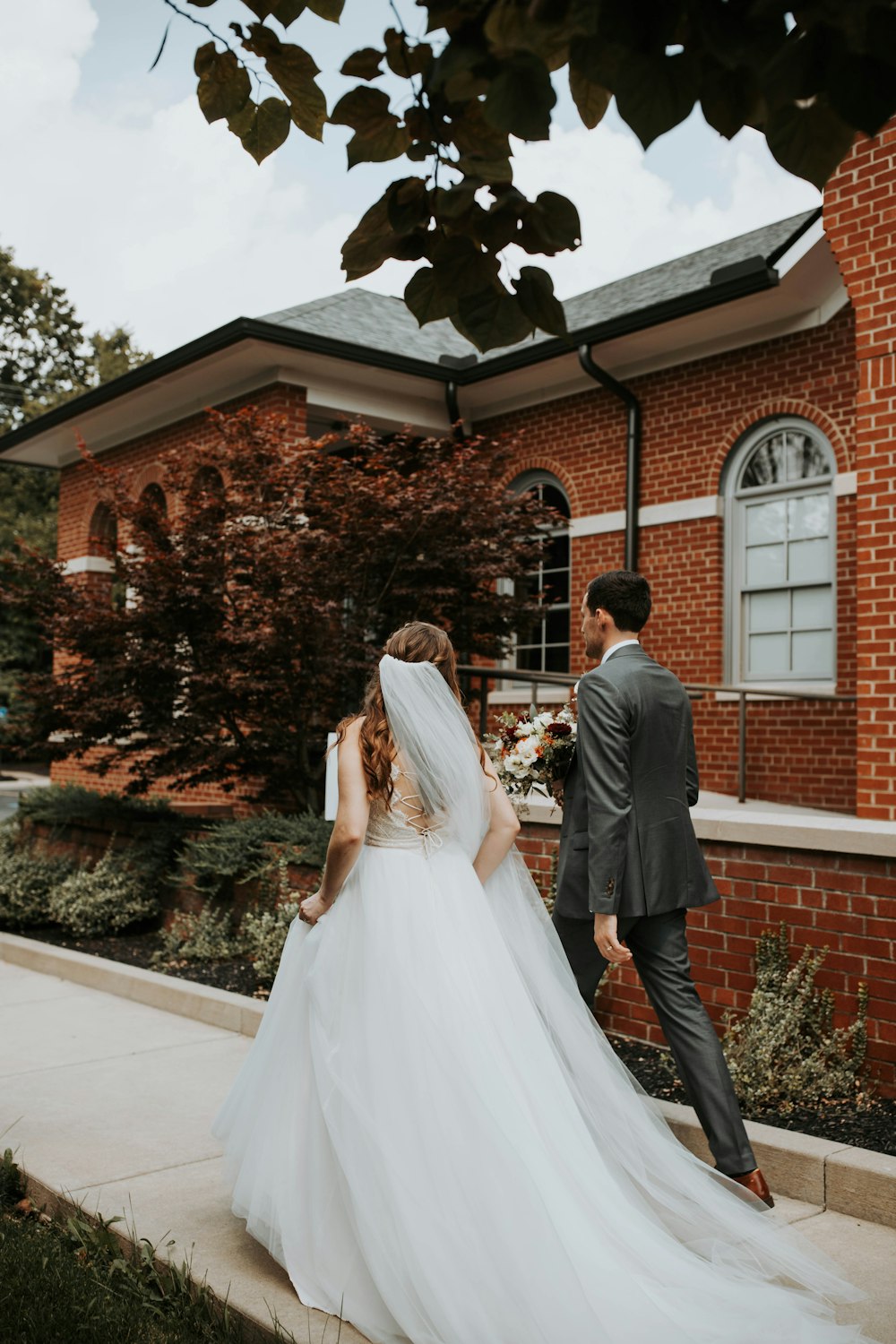 a bride and groom walking away from the church