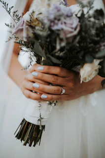 A close-up of the quinceañera's hands holding a delicate bouquet of roses
