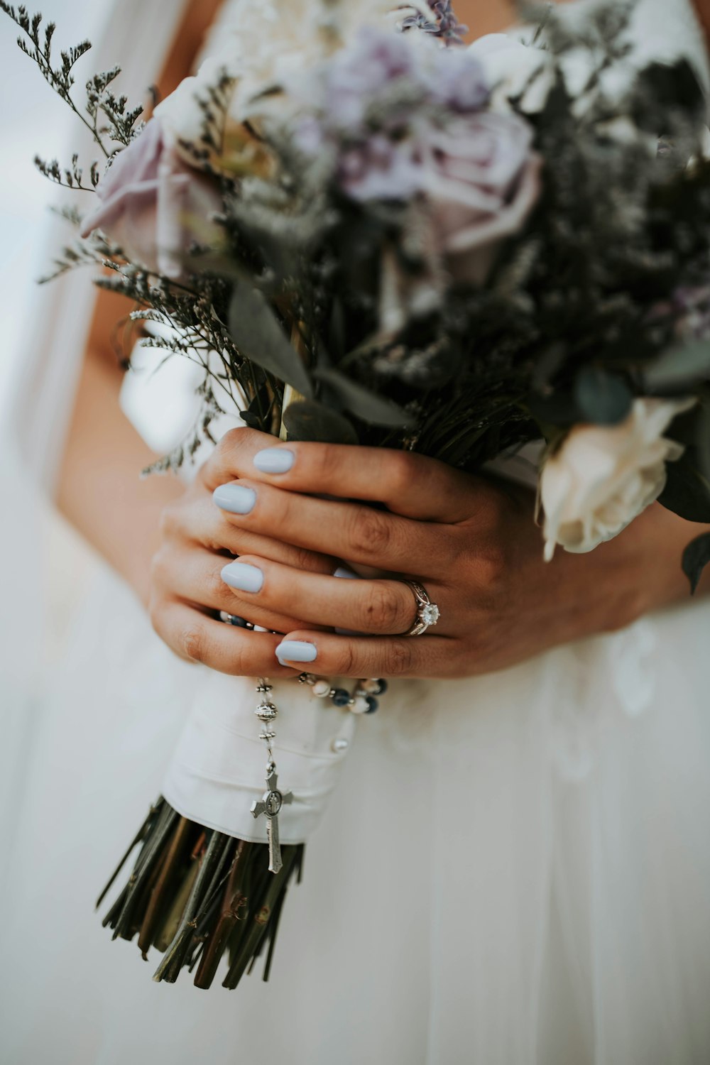Una donna in abito da sposa che tiene un mazzo di fiori