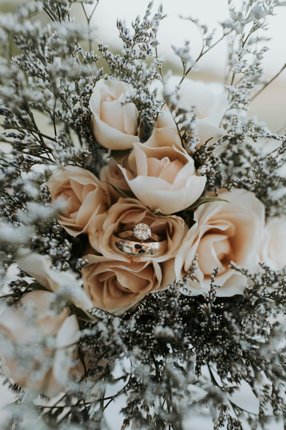 um buquê de flores com um anel de casamento sobre ele