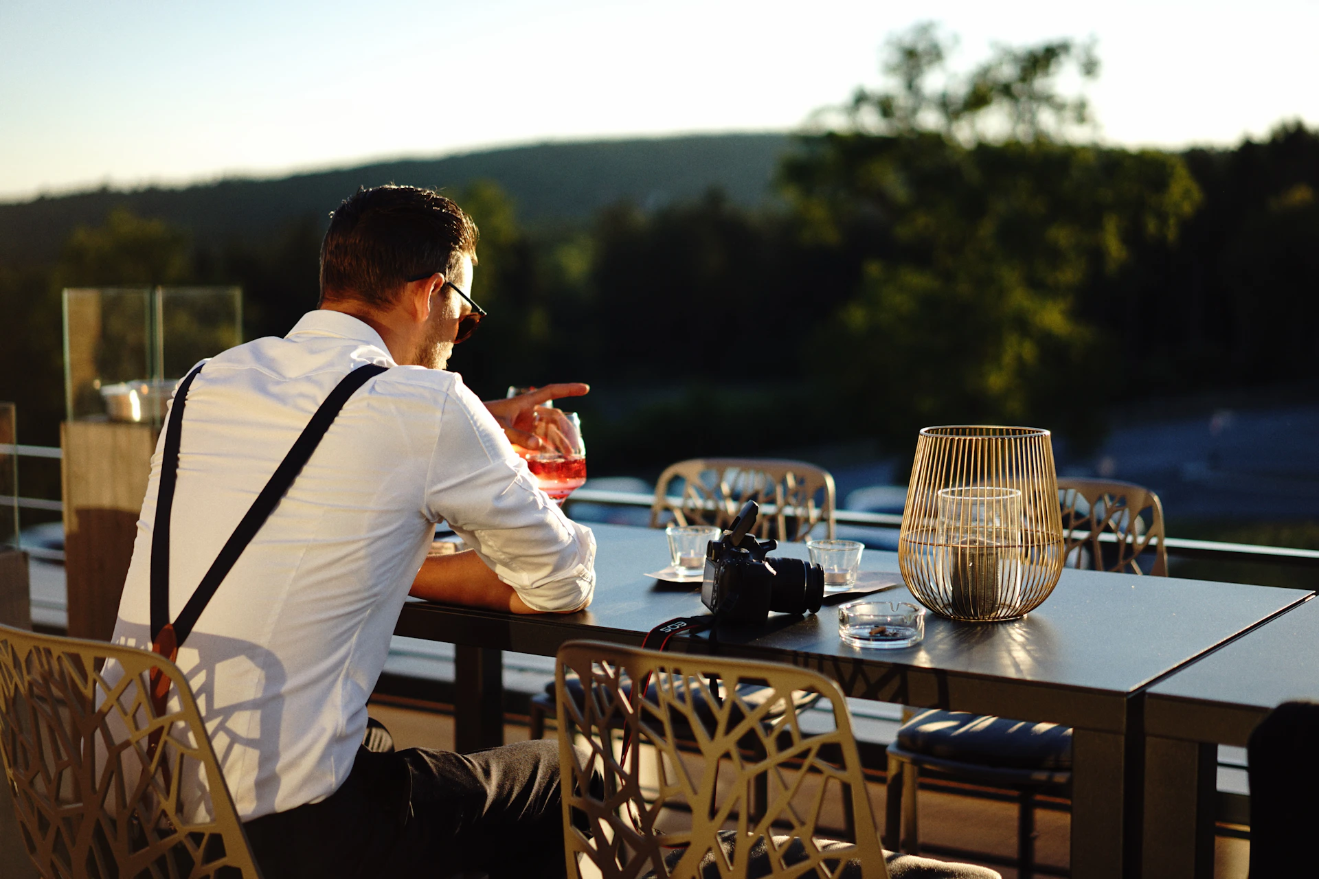 a man sitting at a table with a glass of wine