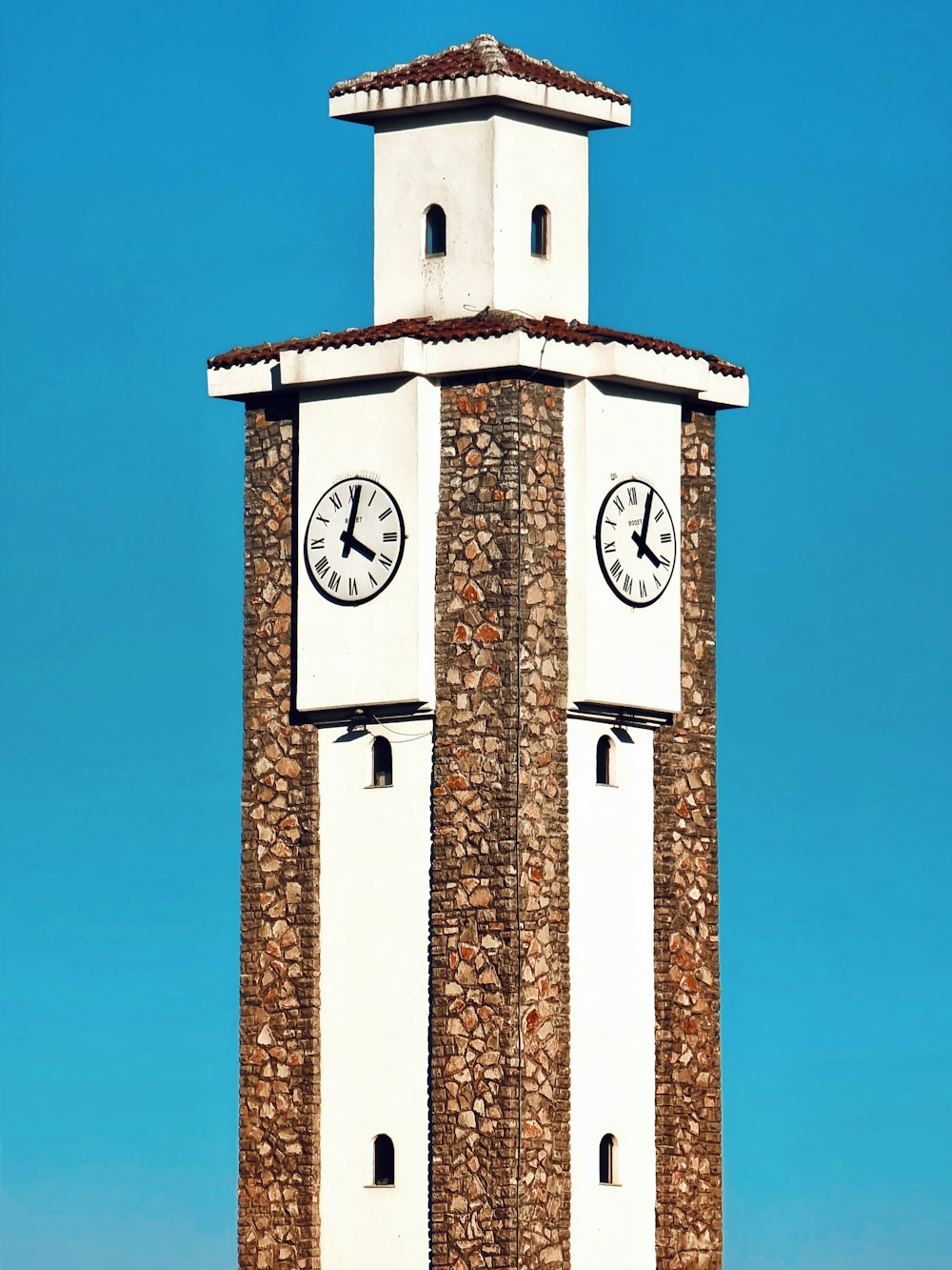 a tall clock tower with two clocks on each of it's sides