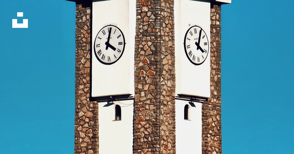 A tall clock tower with two clocks on each of it's sides photo – Free ...