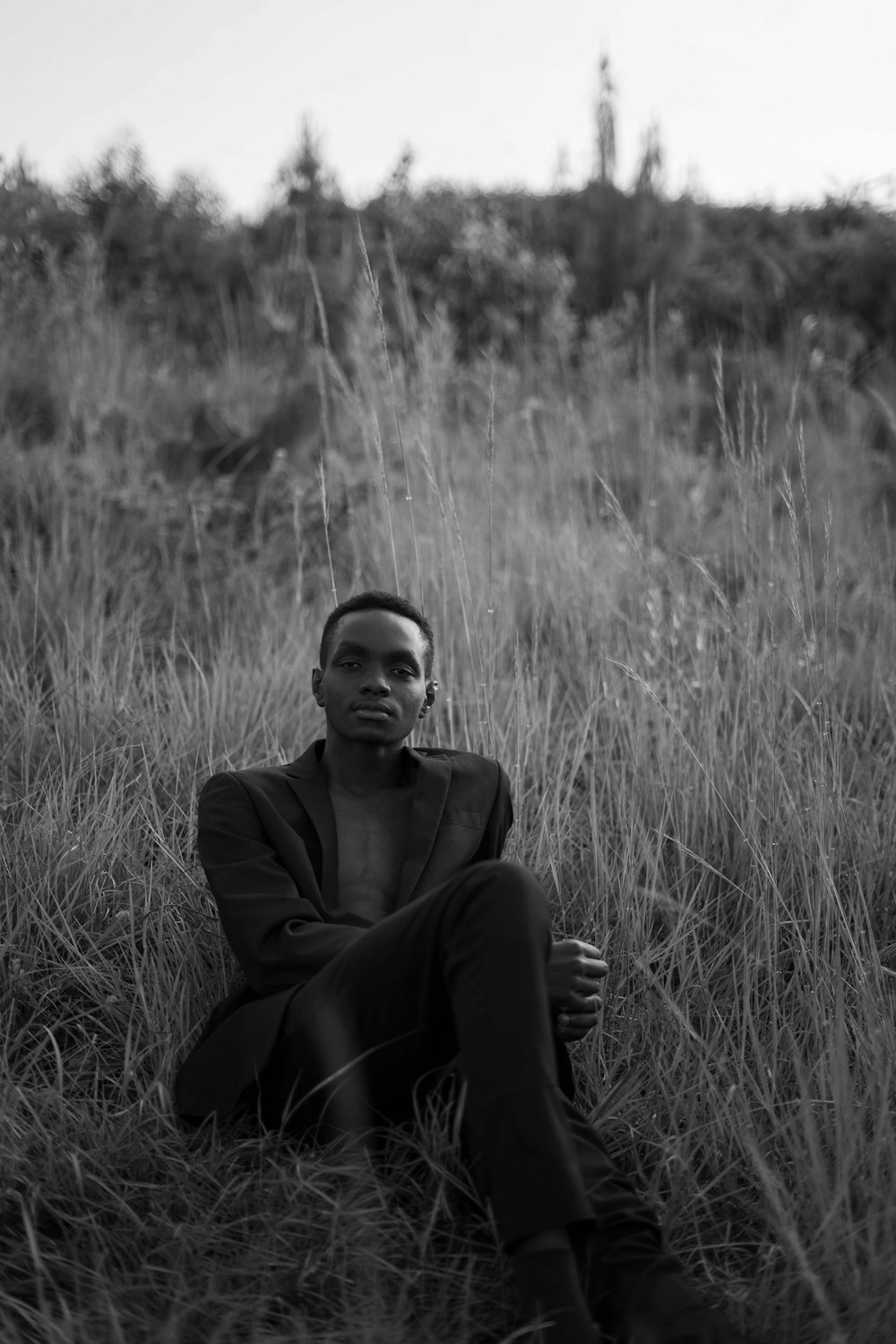 a man sitting in a field of tall grass