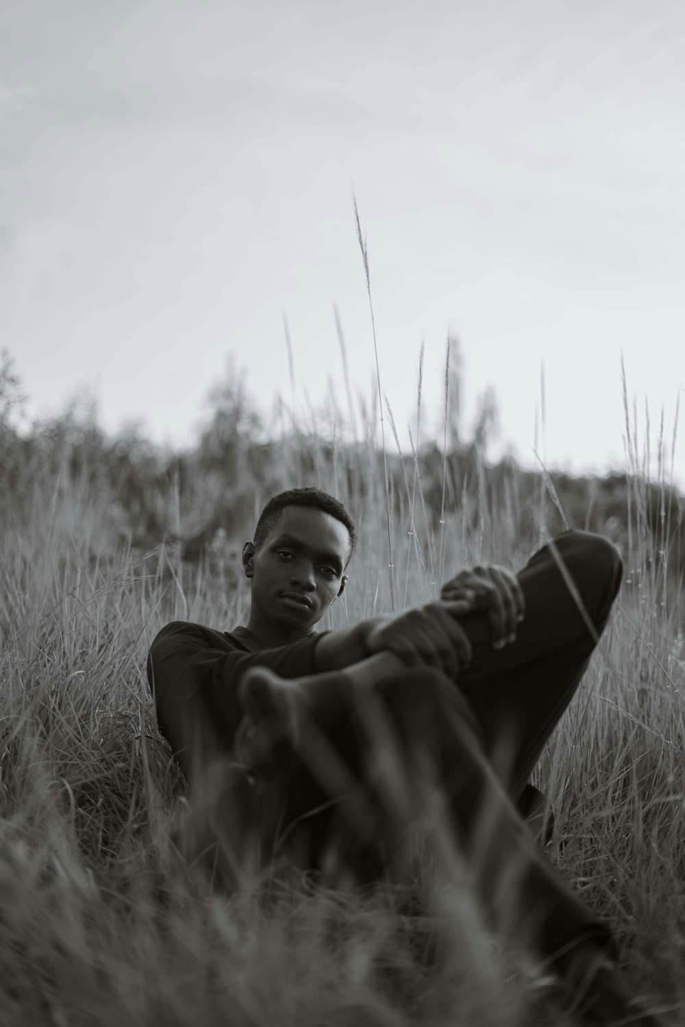 Un hombre sentado en un campo de hierba alta