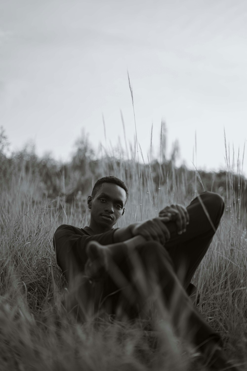 a man sitting in a field of tall grass