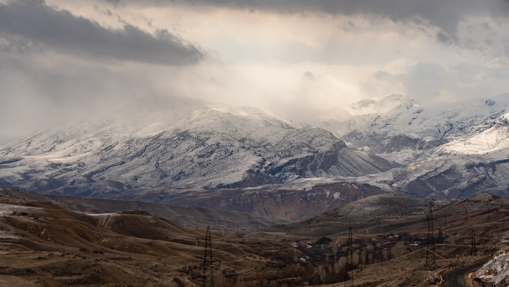 a snow covered mountain range under a cloudy sky