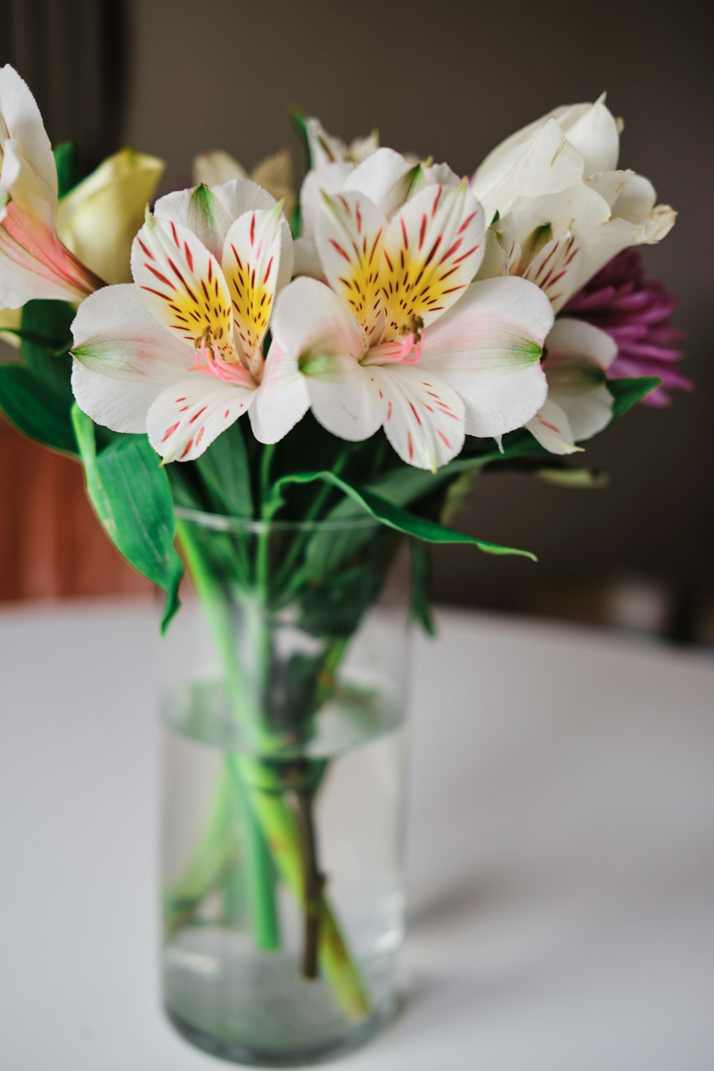 a glass vase filled with white and pink flowers