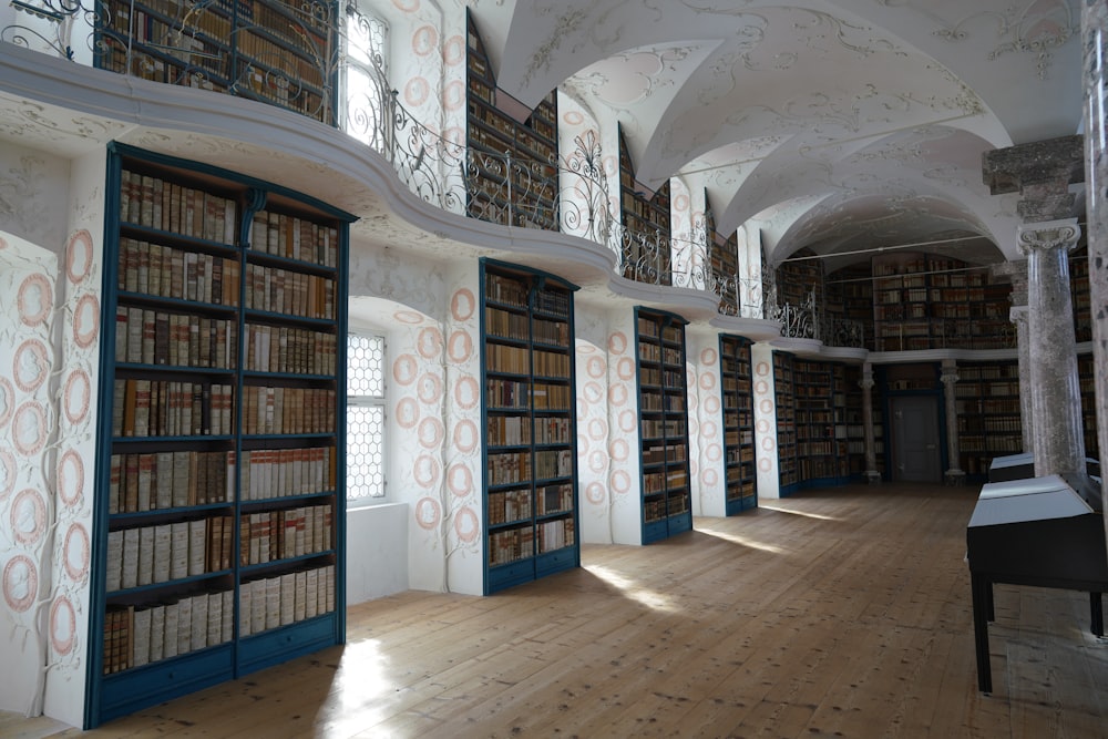 a room with many bookshelves and a piano