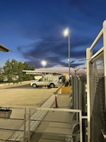Two security guards patrolling a corporate building parking lot during dusk.