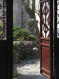 Traditional wooden doors opening to a peaceful garden path.