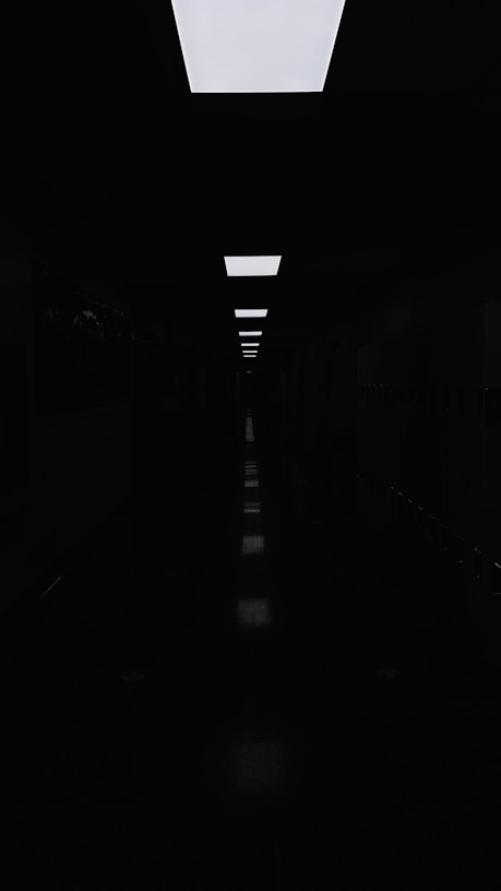 a long dark hallway with a skylight above it