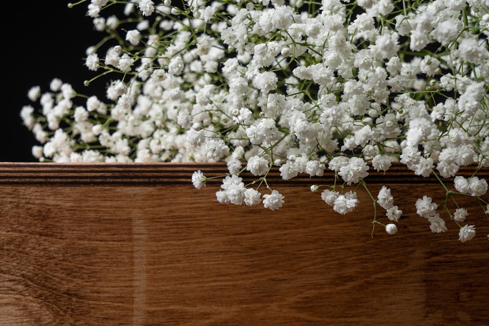 a bunch of white flowers sitting on top of a wooden box