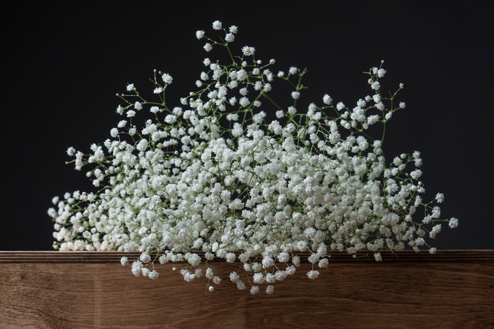 a bunch of white flowers sitting on top of a wooden table