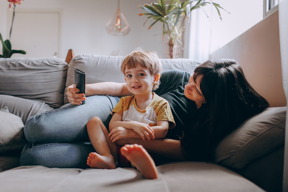 a woman and a child sitting on a couch