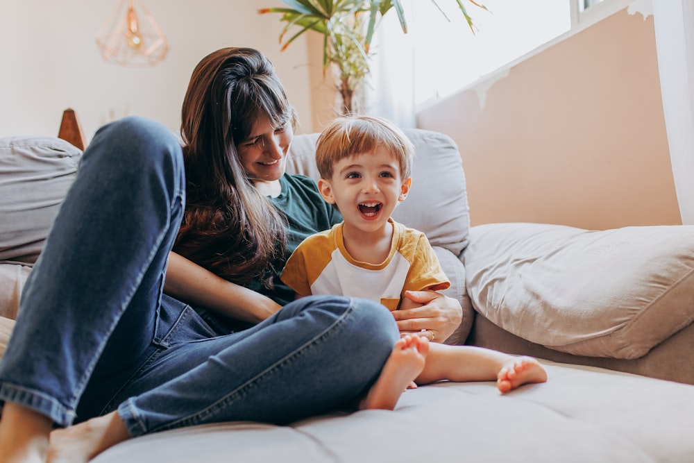 a woman and a child sitting on a couch