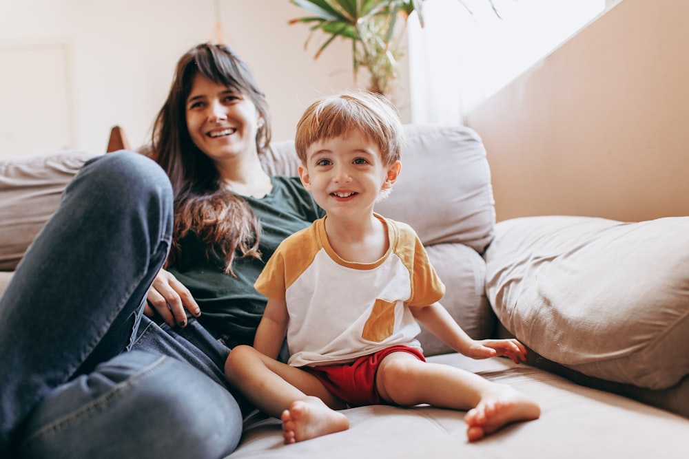 a woman and a child sitting on a couch