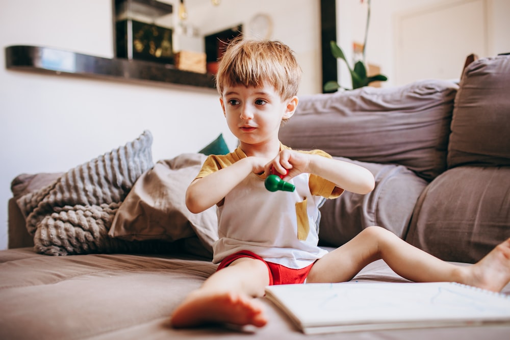 a young boy sitting on the floor playing with a toy