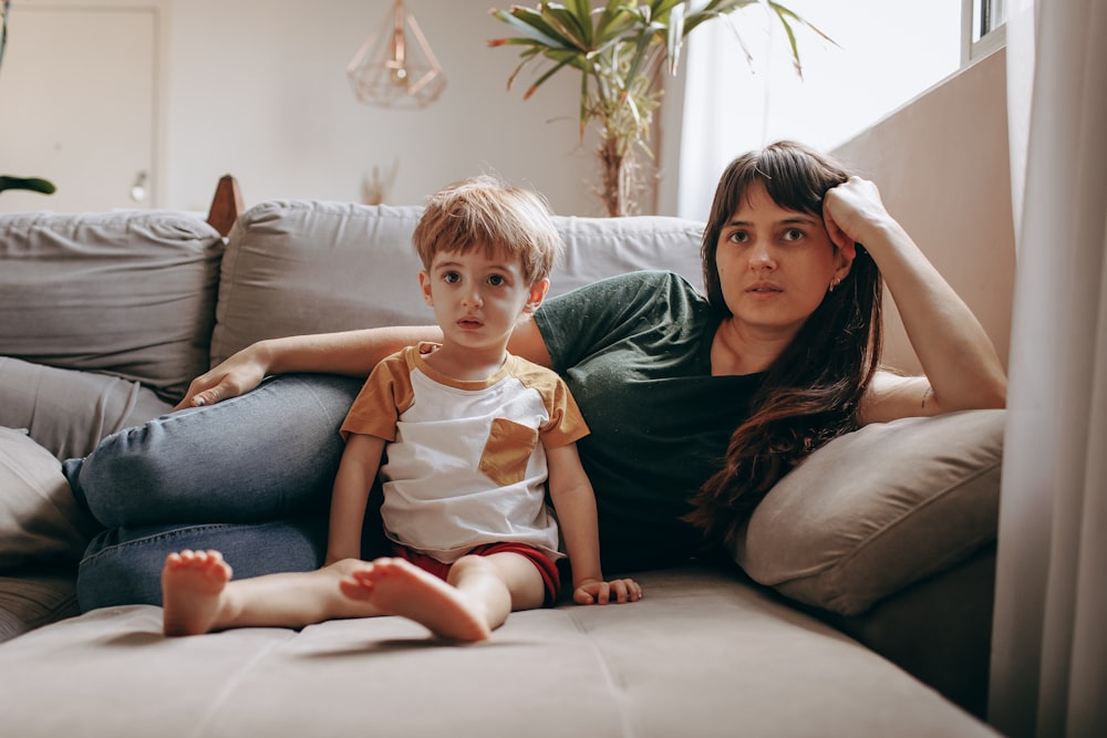 a woman and a child sitting on a couch