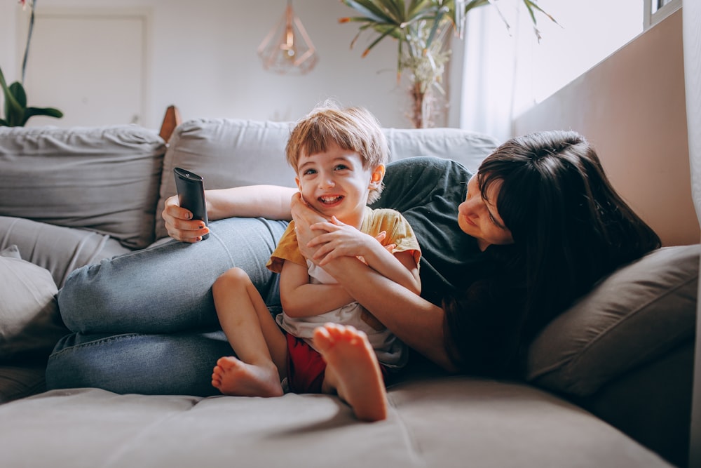 a woman and a child sitting on a couch