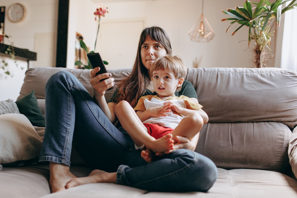 a woman sitting on a couch holding a child